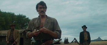 Movie still from “Butch Cassidy and the Sundance Kid” (1969), directed by George Roy Hill – A man holding a pair of scissors in his hand; Medium shot, Low angle