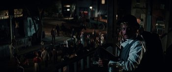 Movie still from “Butch Cassidy and the Sundance Kid” (1969), directed by George Roy Hill – A crowd of people standing on a balcony at night; Medium shot, High angle