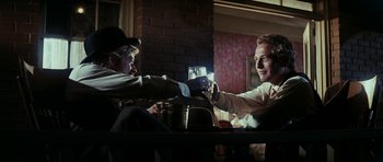 Movie still from “Butch Cassidy and the Sundance Kid” (1969), directed by George Roy Hill – Two men sitting at a dinner table holding hands; Medium shot, Low angle