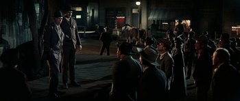 Movie still from “Butch Cassidy and the Sundance Kid” (1969), directed by George Roy Hill – A group of men sitting on the side of a road; Wide shot, Over the shoulder angle