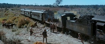 Movie still from “Butch Cassidy and the Sundance Kid” (1969), directed by George Roy Hill – A group of people standing next to an old train; Extreme Wide shot, High angle