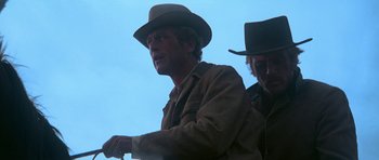 Movie still from “Butch Cassidy and the Sundance Kid” (1969), directed by George Roy Hill – A man in a cowboy hat is looking at something; Medium shot, Low angle