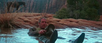 Movie still from “Butch Cassidy and the Sundance Kid” (1969), directed by George Roy Hill – A man in the water with a hat on; Wide shot, Low angle