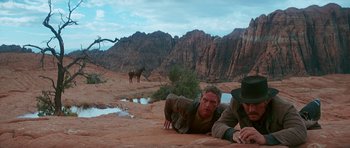 Movie still from “Butch Cassidy and the Sundance Kid” (1969), directed by George Roy Hill – Two men are laying on the ground in the desert; Wide shot, Low angle