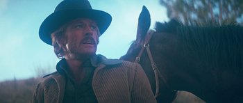 Movie still from “Butch Cassidy and the Sundance Kid” (1969), directed by George Roy Hill – A man with a hat and a horse in the background; Close Up shot, Low angle