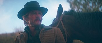 Movie still from “Butch Cassidy and the Sundance Kid” (1969), directed by George Roy Hill – A man in a hat and a brown jacket and a brown horse; Close Up shot, Low angle