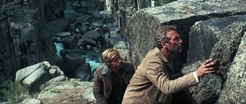 Movie still from “Butch Cassidy and the Sundance Kid” (1969), directed by George Roy Hill – A man and a woman standing next to each other on top of a cliff; Medium shot, High angle