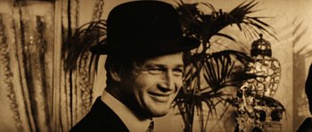 Movie still from “Butch Cassidy and the Sundance Kid” (1969), directed by George Roy Hill – An old photo of a man in a suit and a hat; Close Up shot, Low angle