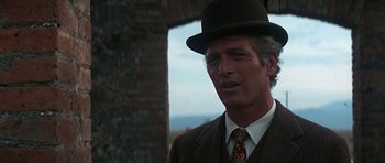 Movie still from “Butch Cassidy and the Sundance Kid” (1969), directed by George Roy Hill – A person wearing a suit and a hat; Close Up shot, Over the shoulder angle
