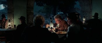 Movie still from “Butch Cassidy and the Sundance Kid” (1969), directed by George Roy Hill – A group of people sitting at a table eating food; Medium shot, Over the shoulder angle