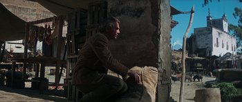 Movie still from “Butch Cassidy and the Sundance Kid” (1969), directed by George Roy Hill – A man kneeling down in front of a wall; Wide shot, Low angle