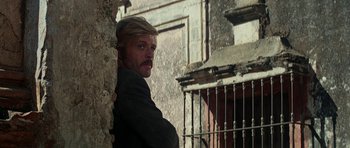 Movie still from “Butch Cassidy and the Sundance Kid” (1969), directed by George Roy Hill – A man leaning against a wall with his hand on his shoulder; Close Up shot, Over the shoulder angle