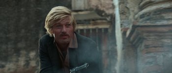 Movie still from “Butch Cassidy and the Sundance Kid” (1969), directed by George Roy Hill – A man holding a gun while wearing a jacket; Close Up shot, Over the shoulder angle