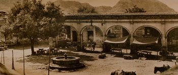 Movie still from “Butch Cassidy and the Sundance Kid” (1969), directed by George Roy Hill – An old photo of a man standing in front of a building; Extreme Wide shot, High angle
