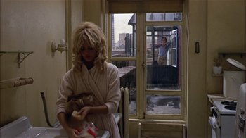 Movie still from “Butterflies Are Free” (1972), directed by Milton Katselas – A woman in a bathrobe and a man in a bathrobe; Wide shot, Over the shoulder angle