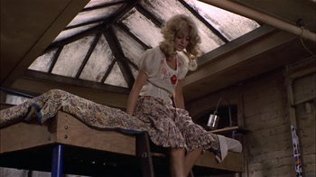 Movie still from “Butterflies Are Free” (1972), directed by Milton Katselas – A woman in a white shirt and a floral skirt; Wide shot, Low angle