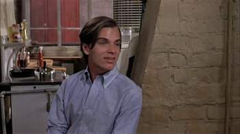 Movie still from “Butterflies Are Free” (1972), directed by Milton Katselas – A man sitting in front of a brick wall; Close Up shot, Over the shoulder angle