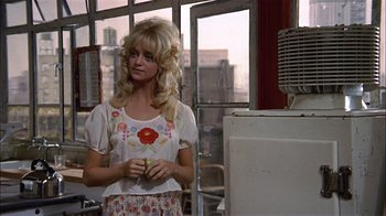 Movie still from “Butterflies Are Free” (1972), directed by Milton Katselas – A woman standing in front of an air conditioner in a room; Medium shot, Over the shoulder angle