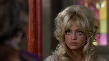 Movie still from “Butterflies Are Free” (1972), directed by Milton Katselas – A person with long blonde hair; Close Up shot, Over the shoulder angle