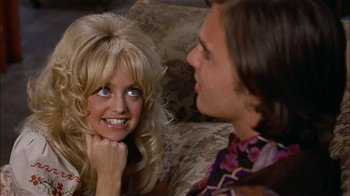 Movie still from “Butterflies Are Free” (1972), directed by Milton Katselas – A man and a woman sitting next to each other on a couch; Close Up shot, Over the shoulder angle