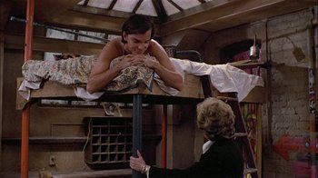 Movie still from “Butterflies Are Free” (1972), directed by Milton Katselas – A man and a woman are sitting on a table; Medium shot, High angle