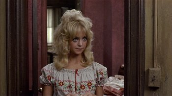 Movie still from “Butterflies Are Free” (1972), directed by Milton Katselas – A woman with blonde hair standing in front of a mirror; Close Up shot, Over the shoulder angle