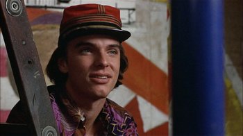 Movie still from “Butterflies Are Free” (1972), directed by Milton Katselas – A man wearing a red hat and a colorful shirt; Close Up shot, Low angle