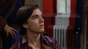Movie still from “Butterflies Are Free” (1972), directed by Milton Katselas – A man with long brown hair wearing a purple shirt; Close Up shot, Over the shoulder angle