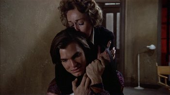 Movie still from “Butterflies Are Free” (1972), directed by Milton Katselas – A woman holding a man's shoulder in a room; Close Up shot, High angle