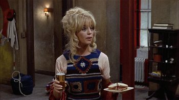 Movie still from “Butterflies Are Free” (1972), directed by Milton Katselas – A woman holding a drink and a plate of food; Medium shot, High angle