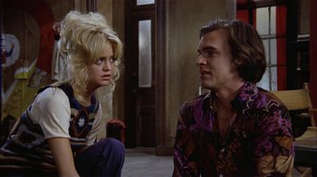 Movie still from “Butterflies Are Free” (1972), directed by Milton Katselas – A man and a woman sitting on the floor; Medium shot, Low angle