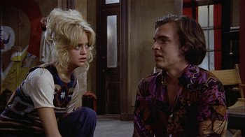 Movie still from “Butterflies Are Free” (1972), directed by Milton Katselas – A man and a woman sitting on the floor; Medium shot, Low angle