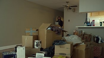 Movie still from “CHIPS” (2017), directed by Dax Shepard – A woman standing in a living room with boxes; Wide shot, High angle