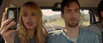 Movie still from “Cabin Fever” (2016), directed by Travis Zariwny – A man and a woman sitting in the back seat of a car; Close Up shot, Low angle
