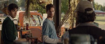 Movie still from “Cabin Fever” (2016), directed by Travis Zariwny – A man standing in front of a tree holding a glass; Medium shot, Over the shoulder angle