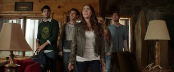 Movie still from “Cabin Fever” (2016), directed by Travis Zariwny – A group of young people standing in a room; Medium shot, Low angle