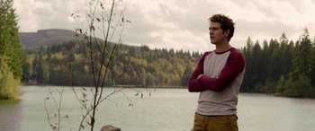 Movie still from “Cabin Fever” (2016), directed by Travis Zariwny – A man standing next to a body of water; Medium shot, Over the shoulder angle