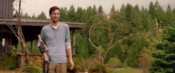 Movie still from “Cabin Fever” (2016), directed by Travis Zariwny – A man standing in front of a tree in a field; Medium shot, Over the shoulder angle