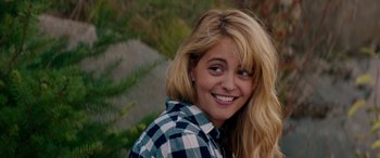 Movie still from “Cabin Fever” (2016), directed by Travis Zariwny – A woman with blonde hair wearing a checkered shirt; Close Up shot, Over the shoulder angle