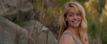 Movie still from “Cabin Fever” (2016), directed by Travis Zariwny – A beautiful young lady smiling for the camera; Close Up shot, Over the shoulder angle