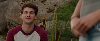 Movie still from “Cabin Fever” (2016), directed by Travis Zariwny – Two young men sitting next to each other in front of some tall grass; Close Up shot, Over the shoulder angle