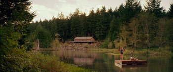 Movie still from “Cabin Fever” (2016), directed by Travis Zariwny – Two people standing on a dock in front of a house; Extreme Wide shot, Low angle