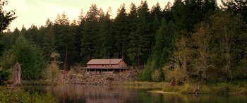 Movie still from “Cabin Fever” (2016), directed by Travis Zariwny – A house sitting next to a body of water; Extreme Wide shot, High angle