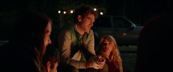 Movie still from “Cabin Fever” (2016), directed by Travis Zariwny – A man and a woman sitting next to each other on the ground; Medium shot, Over the shoulder angle