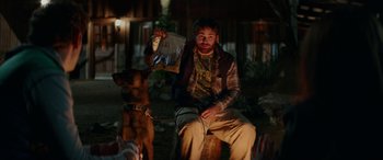 Movie still from “Cabin Fever” (2016), directed by Travis Zariwny – A man sitting on a bench with a dog; Medium shot, Over the shoulder angle