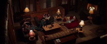 Movie still from “Cabin Fever” (2016), directed by Travis Zariwny – A group of people sitting on a couch in a living room; Wide shot, Overhead angle