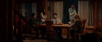 Movie still from “Cabin Fever” (2016), directed by Travis Zariwny – A group of people sitting around a table; Wide shot, Over the shoulder angle