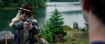 Movie still from “Cabin Fever” (2016), directed by Travis Zariwny – A man in a hat is taking a picture of a tree; Medium shot, Over the shoulder angle