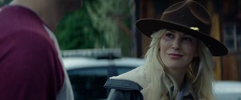 Movie still from “Cabin Fever” (2016), directed by Travis Zariwny – A woman wearing a brown hat and a black jacket; Close Up shot, Over the shoulder angle