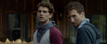 Movie still from “Cabin Fever” (2016), directed by Travis Zariwny – Two men standing next to each other in front of a building; Close Up shot, Over the shoulder angle
